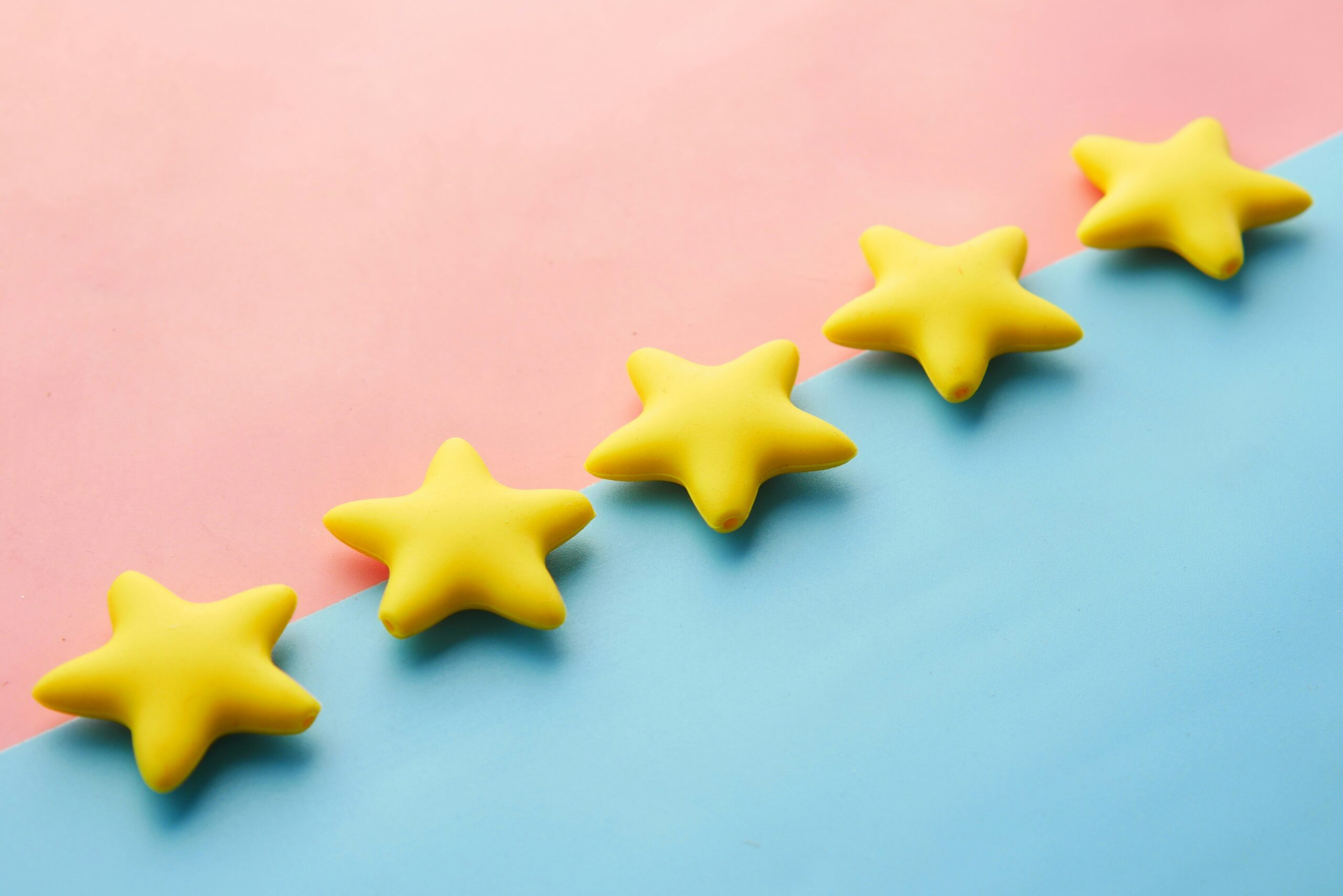 Five yellow stars on a pastel pink and blue background.